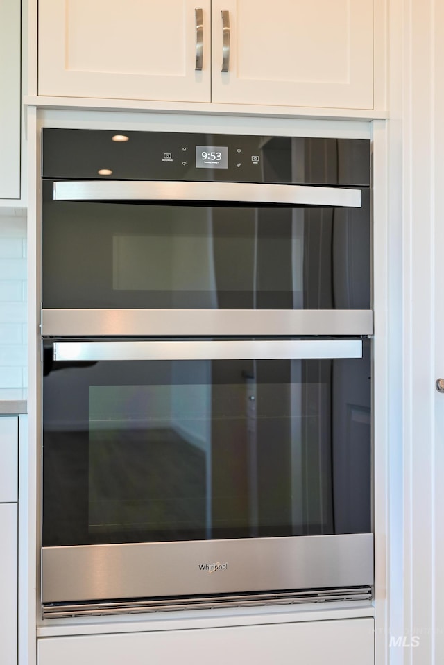 details featuring white cabinets and double oven