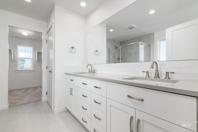 bathroom featuring vanity and a shower with door