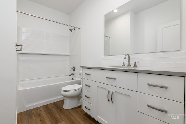 full bathroom with decorative backsplash, shower / bath combination, vanity, hardwood / wood-style floors, and toilet