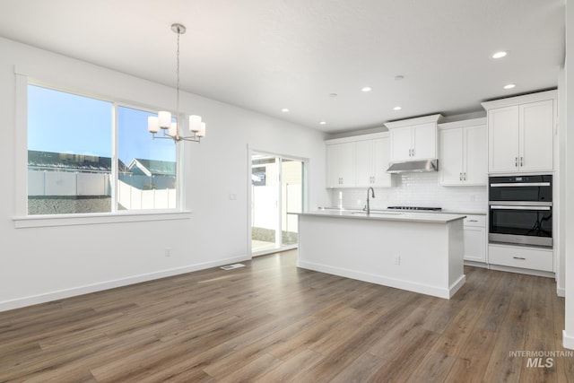 kitchen with pendant lighting, dark hardwood / wood-style floors, white cabinetry, stainless steel double oven, and gas cooktop