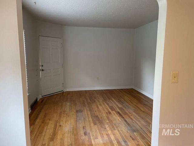 spare room featuring a textured ceiling and hardwood / wood-style flooring