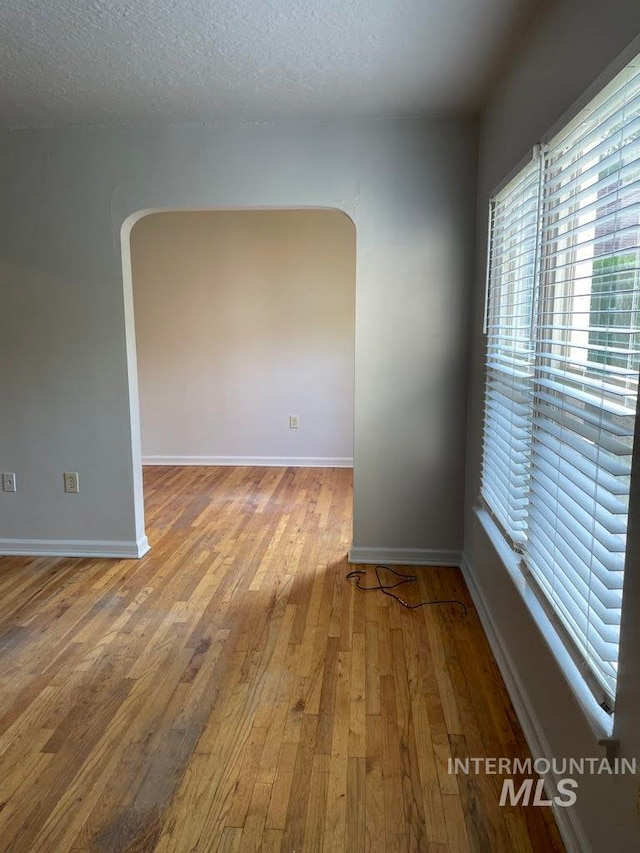 spare room featuring a textured ceiling and hardwood / wood-style flooring