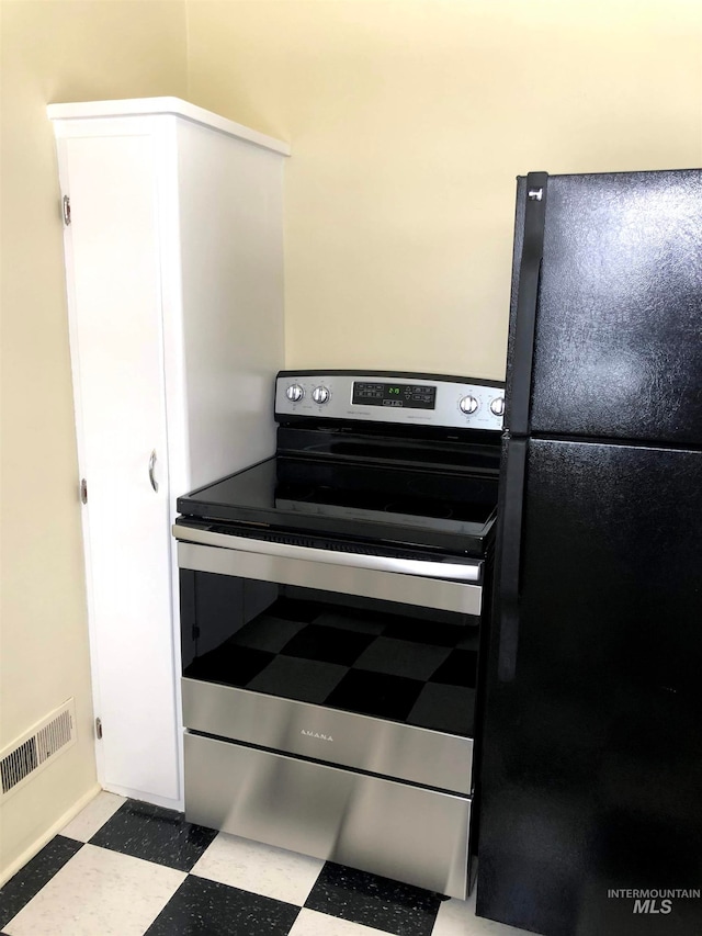 kitchen featuring stainless steel electric range and black refrigerator