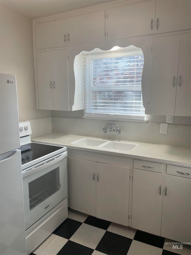 kitchen with white cabinetry, sink, and white appliances