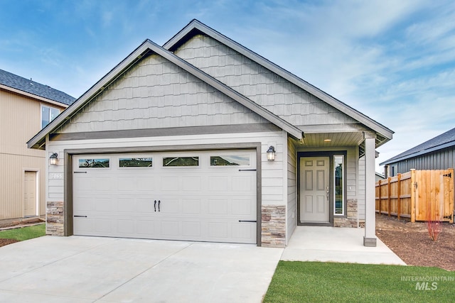 1116 N Peakhurt Ave, Kuna, ID 83634 - view of front of home featuring stone siding, concrete driveway, and a garage