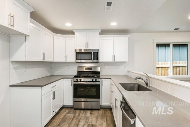 1116 N Peakhurt Ave, Kuna, ID 83634 - kitchen with stainless steel appliances, white cabinets, dark wood-type flooring, tasteful backsplash, and recessed lighting