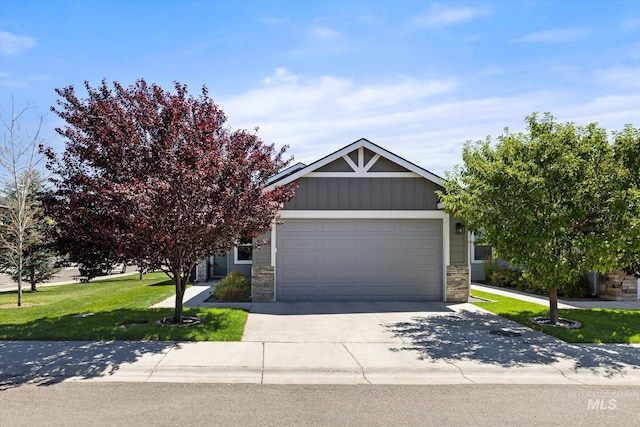 2089 W Claira Rd, Nampa, ID 83651 - obstructed view of property with an attached garage, concrete driveway, a front lawn, and stone siding