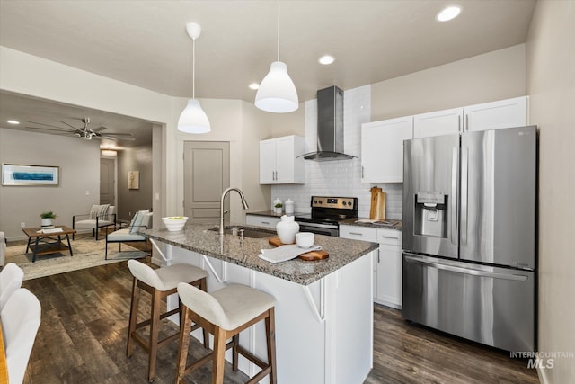 2089 W Claira Rd, Nampa, ID 83651 - kitchen with appliances with stainless steel finishes, wall chimney exhaust hood, dark wood-style floors, a kitchen breakfast bar, and white cabinets