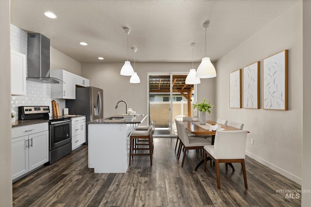 2089 W Claira Rd, Nampa, ID 83651 - kitchen with electric range, wall chimney range hood, a kitchen bar, dark wood-style flooring, and recessed lighting
