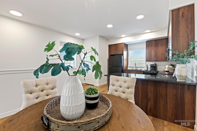 7439 W Swain Ln, Garden City, ID 83714 - kitchen featuring decorative backsplash, a sink, freestanding refrigerator, light wood-style flooring, and a peninsula