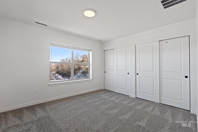 7439 W Swain Ln, Garden City, ID 83714 - unfurnished bedroom featuring carpet, baseboards, visible vents, and two closets