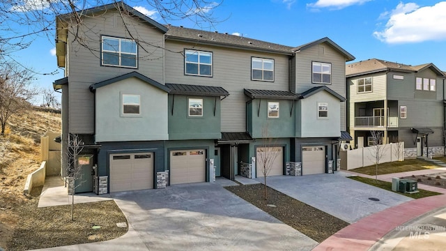 7439 W Swain Ln, Garden City, ID 83714 - townhome / multi-family property featuring metal roof, stone siding, a garage, and driveway