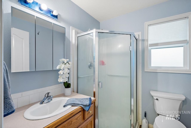 bathroom featuring vanity, walk in shower, and toilet