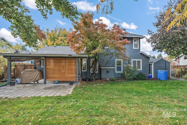 back of house featuring a lawn and a patio area