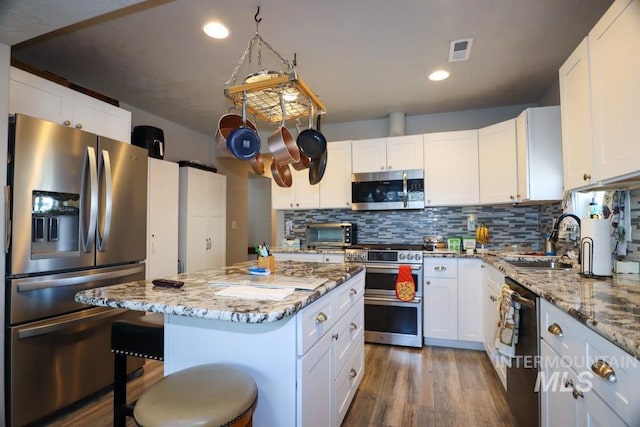 kitchen featuring visible vents, dark wood-style flooring, a sink, and appliances with stainless steel finishes