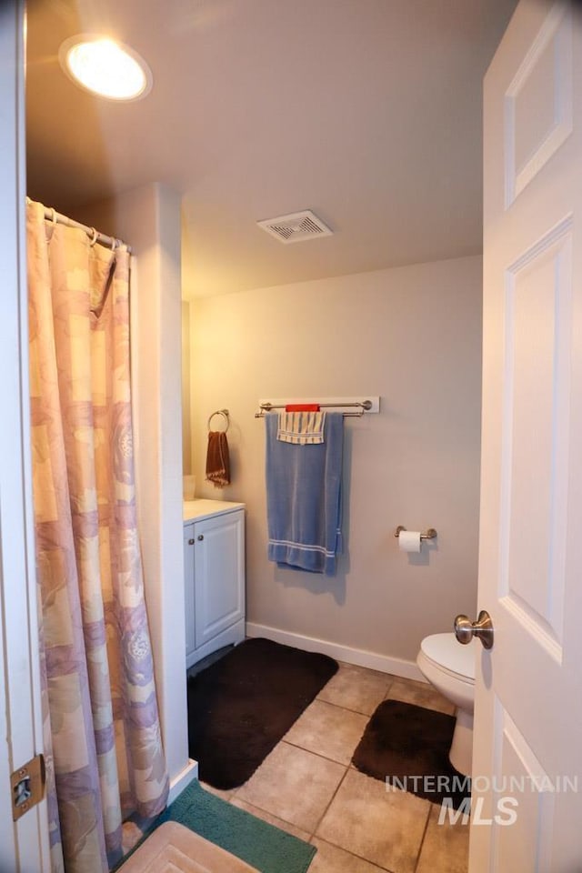 bathroom featuring vanity, tile patterned flooring, visible vents, toilet, and baseboards