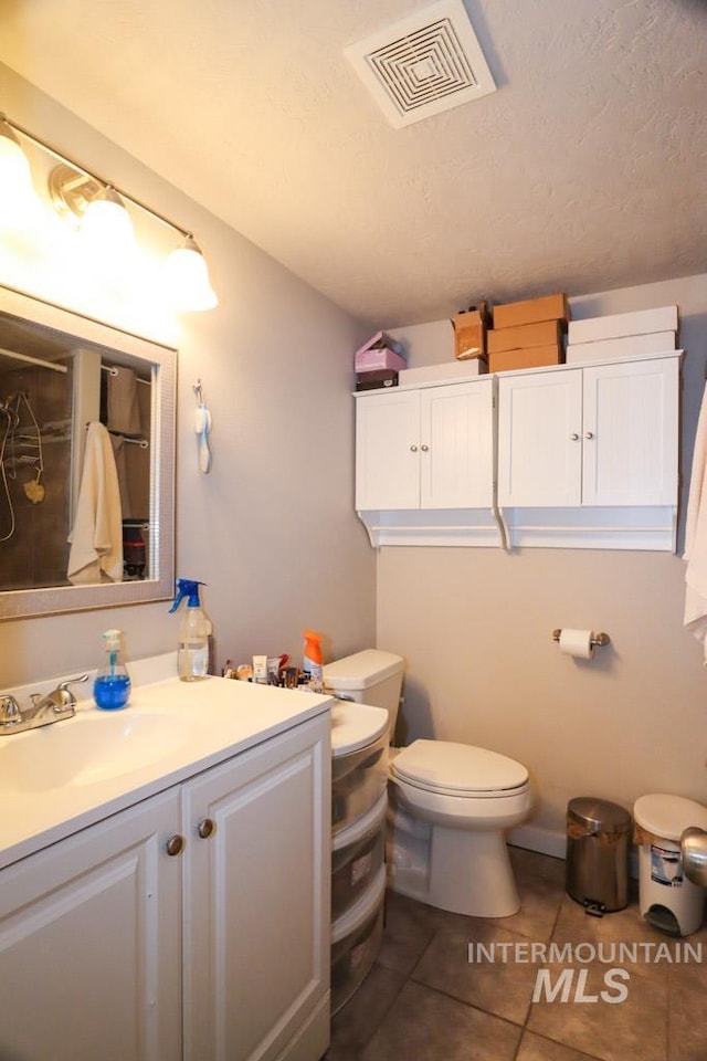 full bath featuring toilet, tile patterned floors, vanity, and visible vents