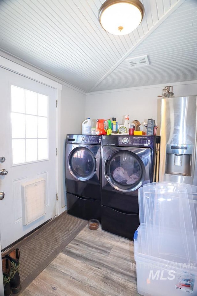 washroom with visible vents, laundry area, wood ceiling, wood finished floors, and washing machine and dryer