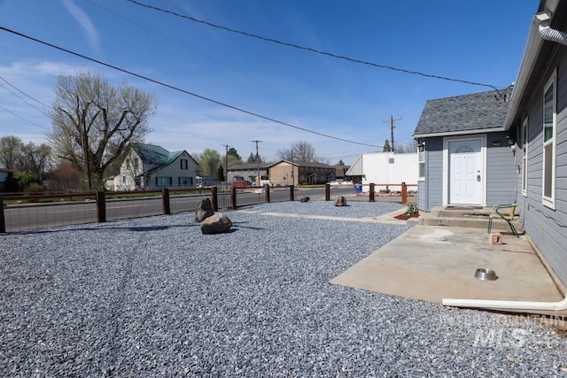 view of yard featuring a residential view, a patio area, and fence