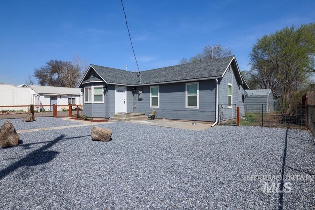 view of front of property with a shingled roof and fence