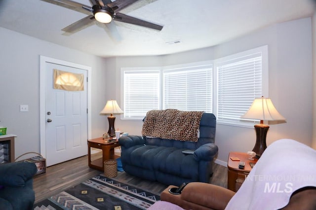 living room with visible vents, a ceiling fan, and wood finished floors