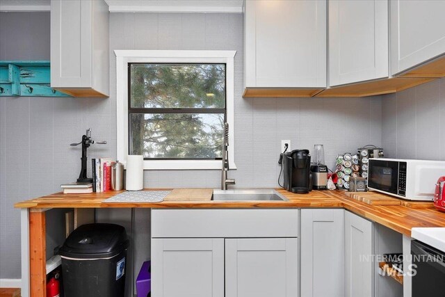 186 Phillips Creek Ln, Fairfield, ID 83327 - kitchen featuring white microwave, butcher block counters, a sink, backsplash, and white cabinetry