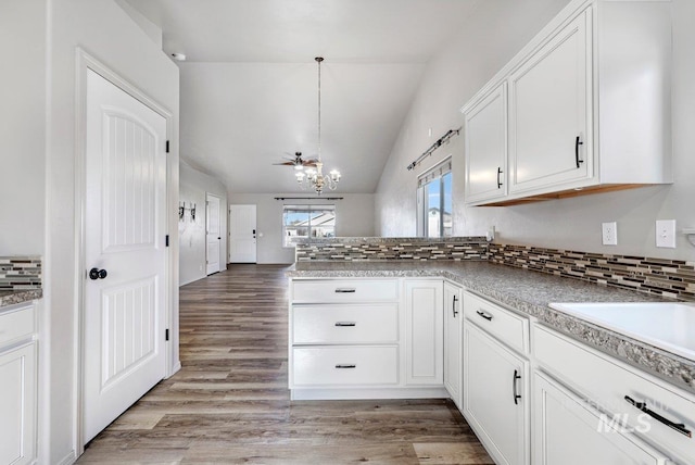 1022 S Date St, Jerome, ID 83338 - kitchen featuring a peninsula, lofted ceiling, a chandelier, backsplash, and white cabinetry