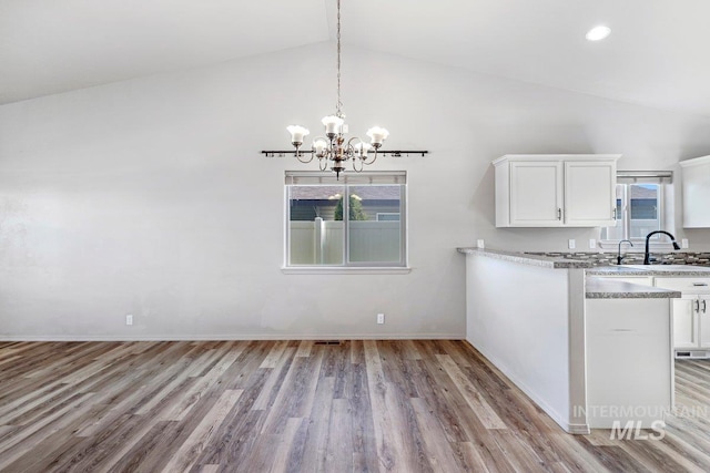 1022 S Date St, Jerome, ID 83338 - kitchen featuring a chandelier, wood finished floors, high vaulted ceiling, white cabinets, and pendant lighting