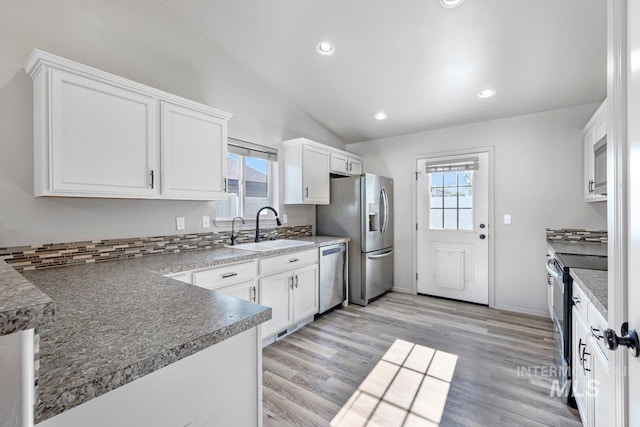 1022 S Date St, Jerome, ID 83338 - kitchen with appliances with stainless steel finishes, vaulted ceiling, white cabinetry, light wood-style flooring, and recessed lighting