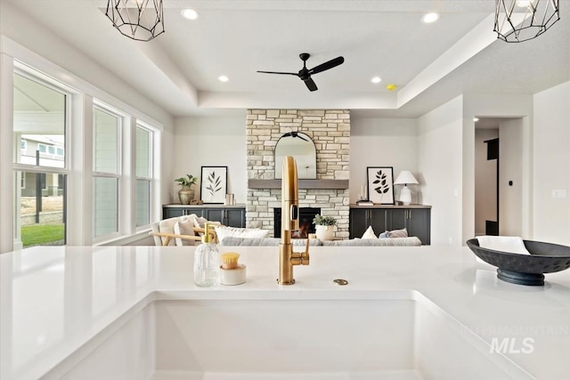 7680 W Old School St, Meridian, ID 83646 - kitchen with ceiling fan, a sink, a stone fireplace, a raised ceiling, and recessed lighting