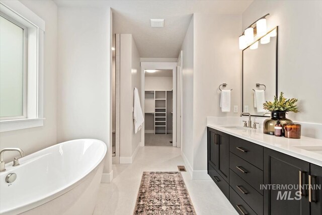 7680 W Old School St, Meridian, ID 83646 - full bathroom featuring a freestanding tub, double vanity, a spacious closet, and baseboards