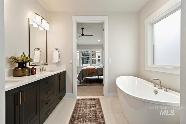 7680 W Old School St, Meridian, ID 83646 - full bathroom with double vanity, a freestanding tub, ceiling fan, tile patterned flooring, and baseboards