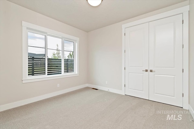 7680 W Old School St, Meridian, ID 83646 - unfurnished bedroom with baseboards, light colored carpet, and a closet