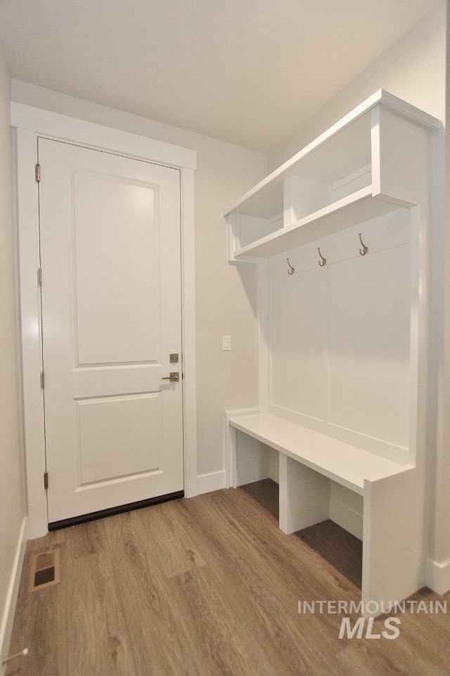 mudroom featuring wood finished floors, visible vents, and baseboards