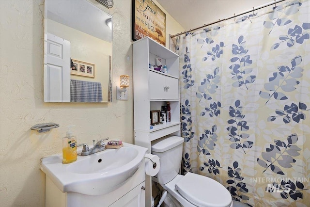722 Nevada St, Gooding, ID 83330 - full bathroom featuring toilet, vanity, a textured wall, and curtained shower