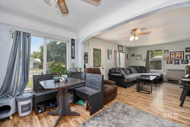 722 Nevada St, Gooding, ID 83330 - dining area featuring ceiling fan, radiator, arched walkways, and wood finished floors