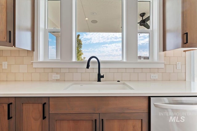 kitchen featuring sink, backsplash, and dishwasher