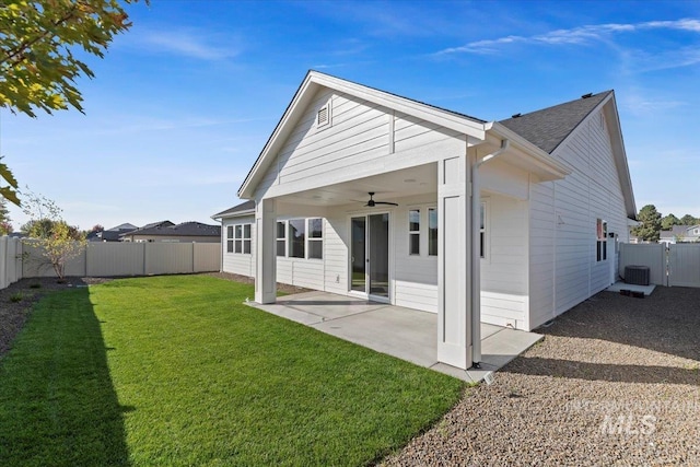 rear view of house featuring cooling unit, ceiling fan, a patio, and a lawn