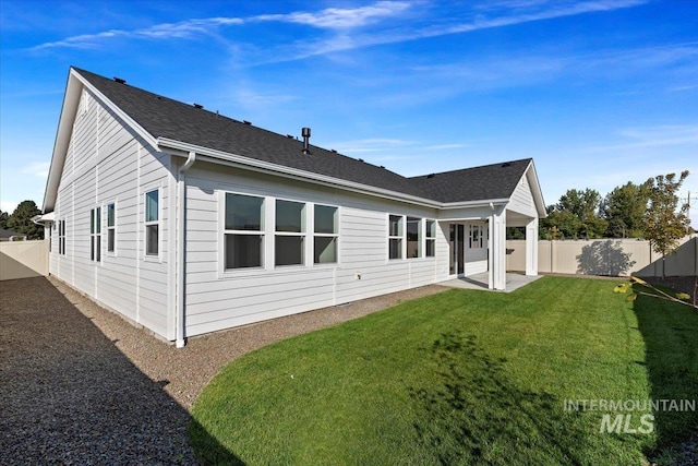 back of house featuring a patio area and a lawn