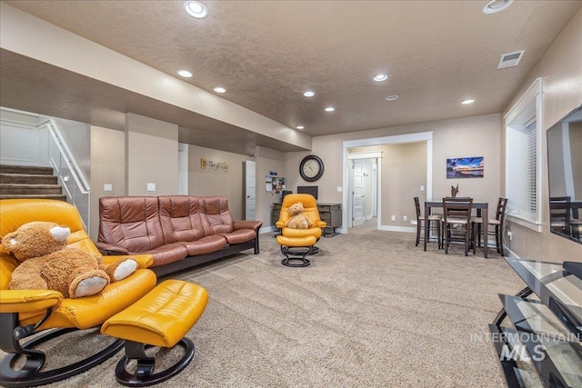 living area featuring visible vents, baseboards, recessed lighting, a textured ceiling, and carpet flooring