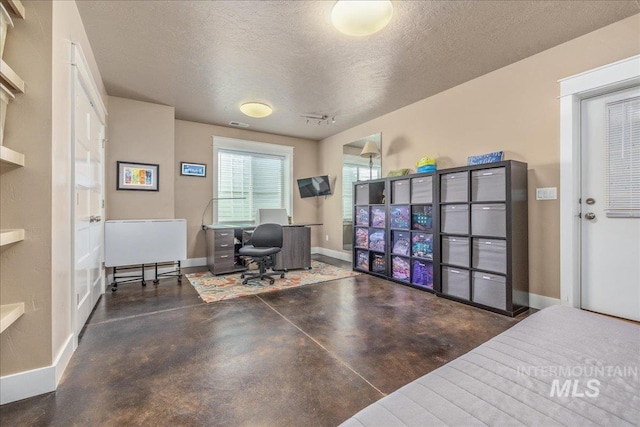 office area featuring finished concrete floors, a textured ceiling, and baseboards
