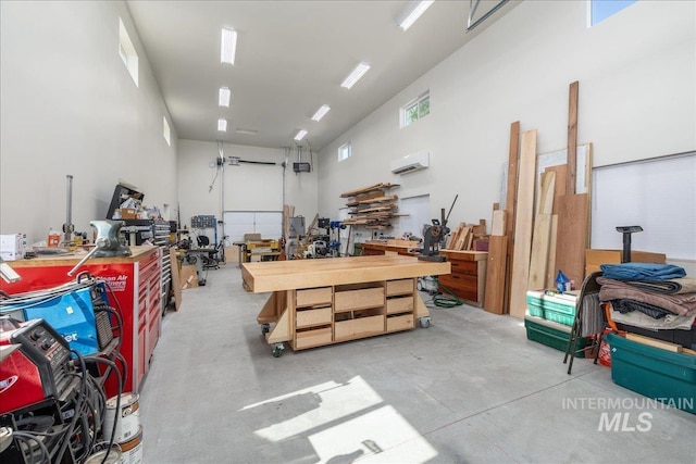 garage featuring an AC wall unit and a workshop area