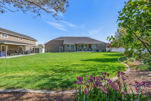 rear view of property with a lawn, a patio, and fence