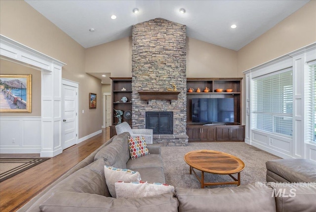 living room featuring a decorative wall, wood finished floors, a fireplace, high vaulted ceiling, and recessed lighting