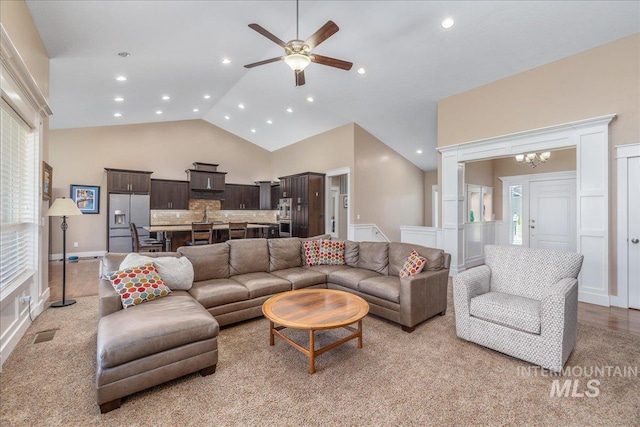 living area with light colored carpet, high vaulted ceiling, ceiling fan with notable chandelier, recessed lighting, and visible vents