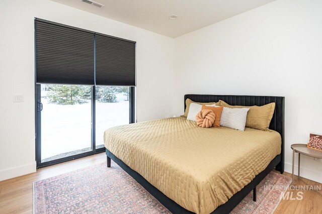 1047 Kaitlyn Loop, Mccall, ID 83638 - bedroom featuring access to exterior, light wood-style floors, and baseboards