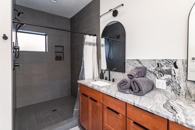 1047 Kaitlyn Loop, Mccall, ID 83638 - bathroom featuring tiled shower, decorative backsplash, and double vanity