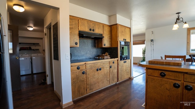 kitchen featuring dark wood finished floors, brown cabinets, washing machine and clothes dryer, under cabinet range hood, and black appliances