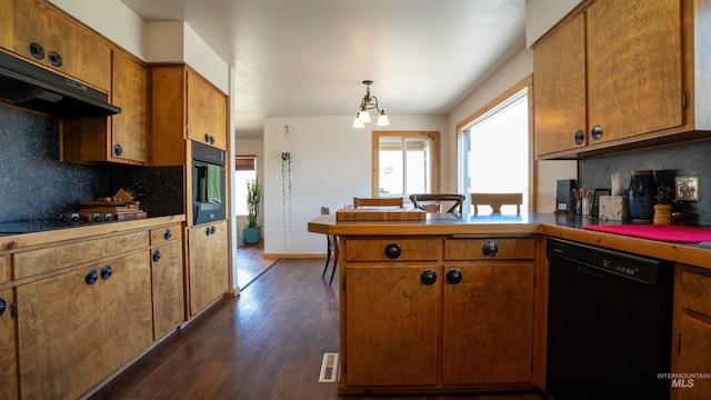 kitchen with under cabinet range hood, a peninsula, backsplash, black appliances, and brown cabinetry