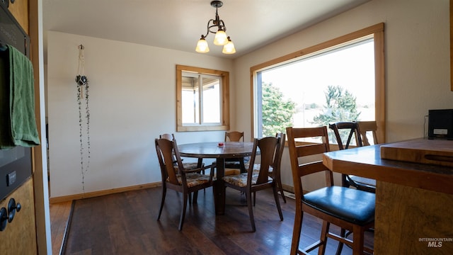 dining space with an inviting chandelier, baseboards, and wood finished floors